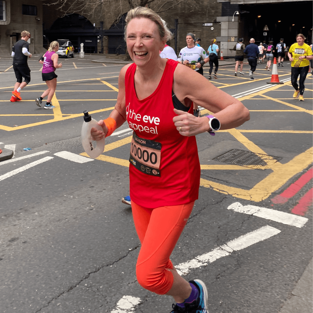 person wearing an eve running t-shirt and running with a smile